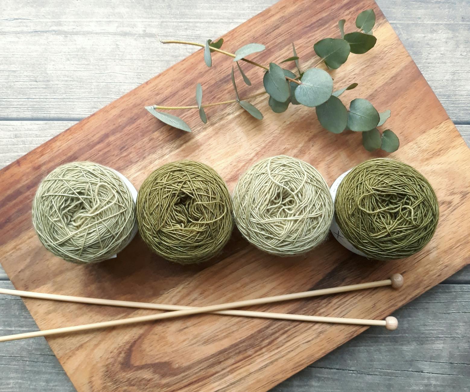 four green yarns on chopping board