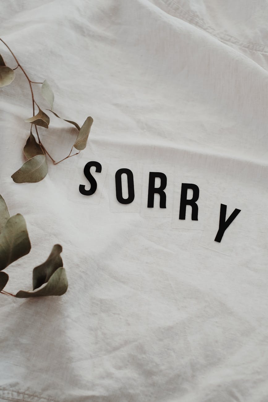 word sorry on white fabric