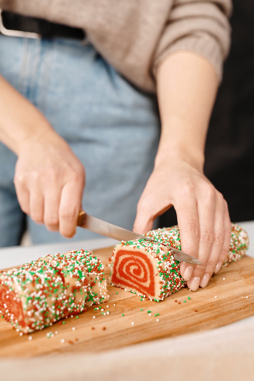 person slicing a cake into pieces