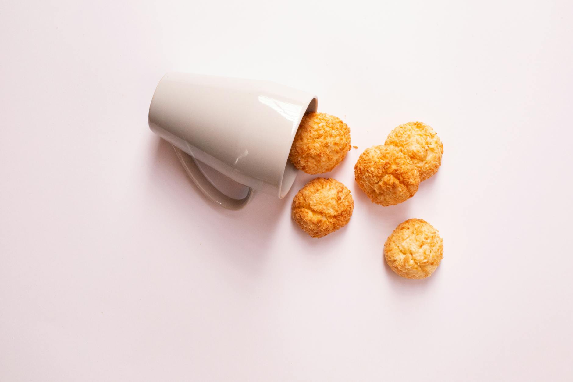 five cream puffs beside white mug