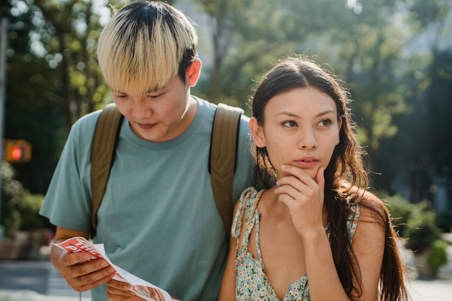 young diverse lost couple finding route in map